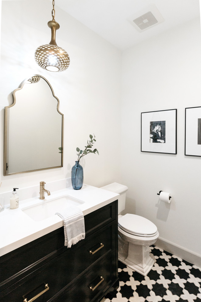 Inspiration for a mediterranean powder room in Los Angeles with recessed-panel cabinets, black cabinets, white walls, an undermount sink, multi-coloured floor and white benchtops.