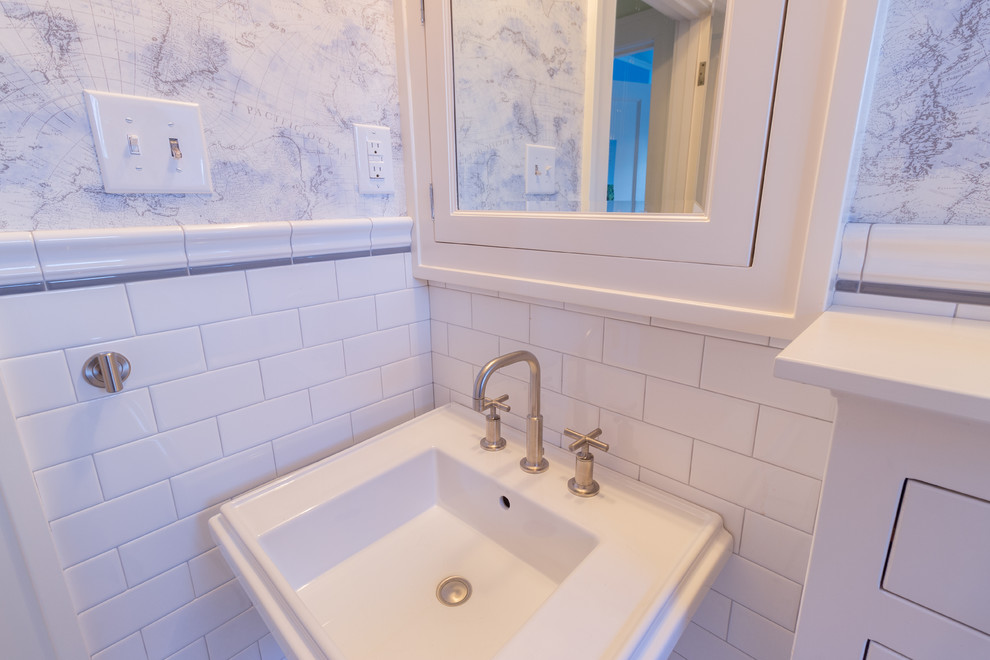 Photo of a mid-sized transitional kids bathroom in Minneapolis with an alcove tub, a one-piece toilet, white tile, subway tile, multi-coloured walls and a pedestal sink.