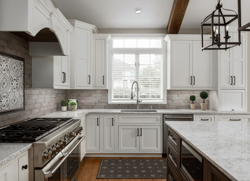 Example of a large transitional l-shaped medium tone wood floor and brown floor eat-in kitchen design in St Louis with an undermount sink, flat-panel cabinets, white cabinets, quartz countertops, gray backsplash, ceramic backsplash, stainless steel appliances, an island and white countertops