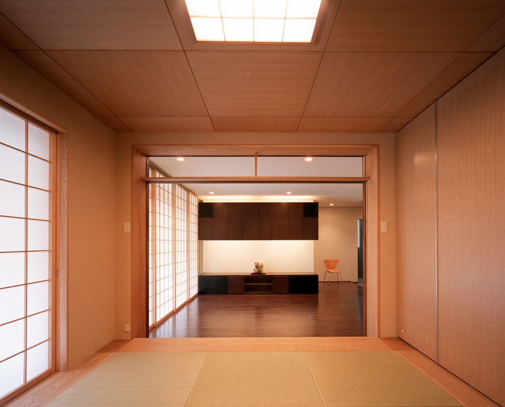 Design ideas for a mid-sized asian guest bedroom in Tokyo with beige walls, tatami floors, no fireplace, a plaster fireplace surround and beige floor.