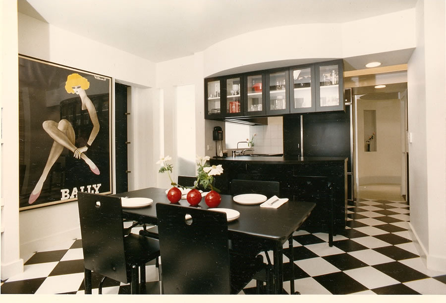 Expansive modern u-shaped open plan kitchen in New York with a single-bowl sink, flat-panel cabinets, black cabinets, laminate benchtops, black splashback, cement tile splashback, black appliances and ceramic floors.