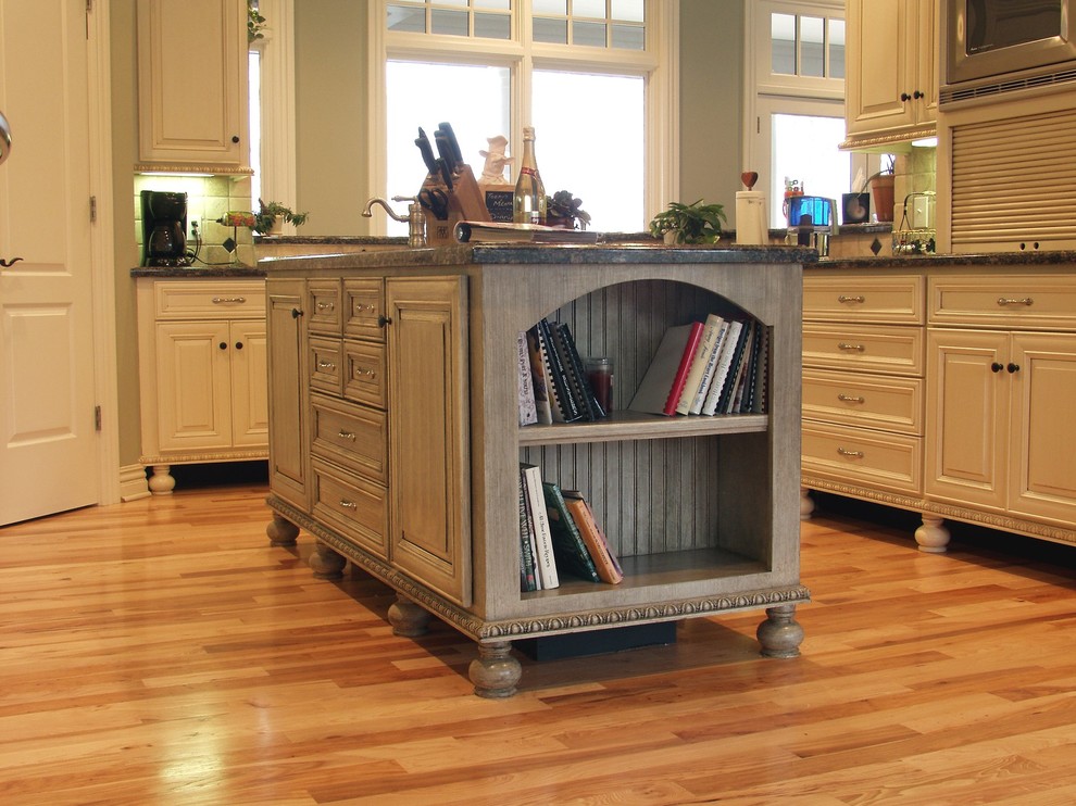 Kitchen pantry - large l-shaped medium tone wood floor kitchen pantry idea with an undermount sink, shaker cabinets, white cabinets, granite countertops, green backsplash, matchstick tile backsplash, stainless steel appliances and an island