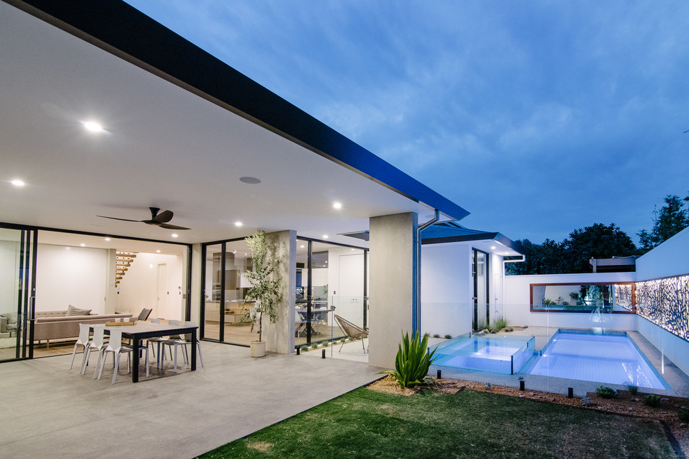This is an example of a mid-sized contemporary backyard lap pool in Adelaide with concrete slab.