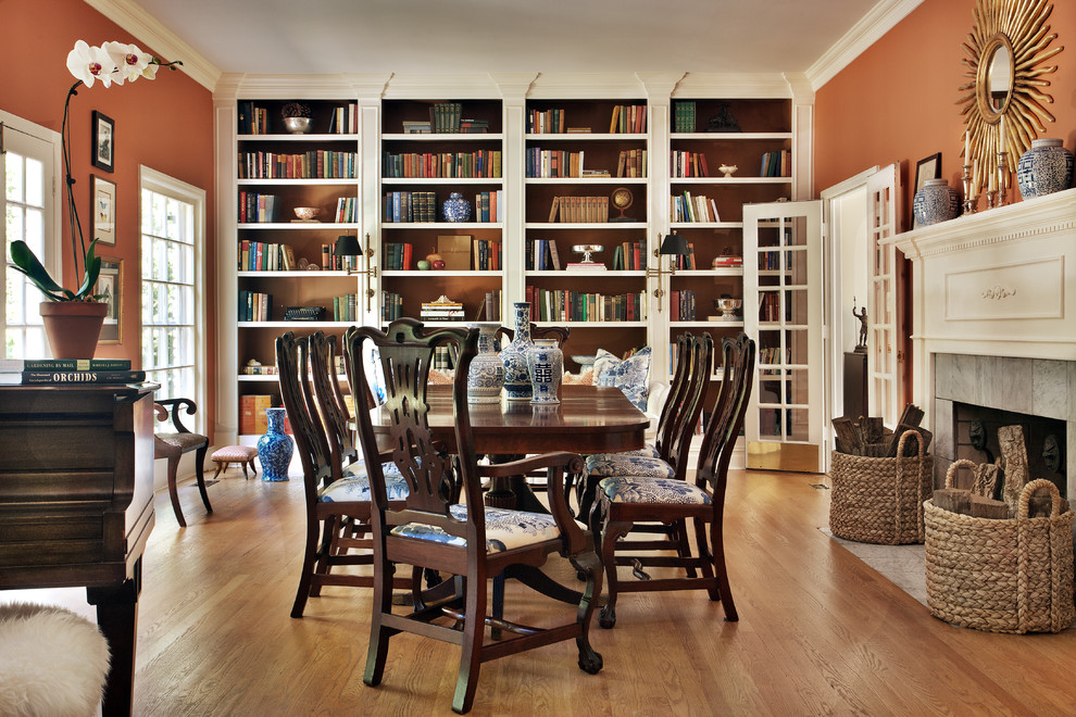 Design ideas for a large traditional separate dining room in New York with orange walls, medium hardwood floors, a standard fireplace, a tile fireplace surround and brown floor.