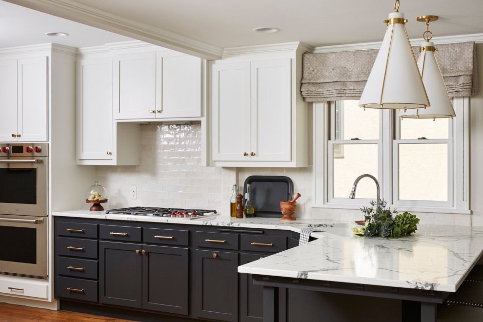 Mid-sized transitional kitchen in Minneapolis with an undermount sink, recessed-panel cabinets, black cabinets, quartzite benchtops, white splashback, ceramic splashback, stainless steel appliances, medium hardwood floors, a peninsula, brown floor and white benchtop.