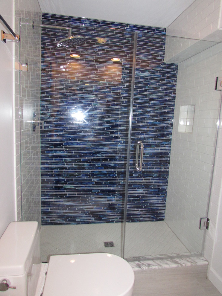 This is an example of a mid-sized contemporary 3/4 bathroom in DC Metro with an alcove shower, a two-piece toilet, white tile, ceramic tile, white walls and ceramic floors.
