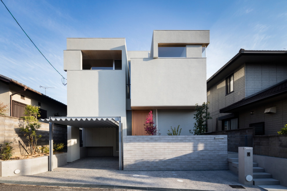 Foto de fachada de casa blanca y gris minimalista de tamaño medio a niveles con revestimiento de estuco, tejado plano y tejado de varios materiales