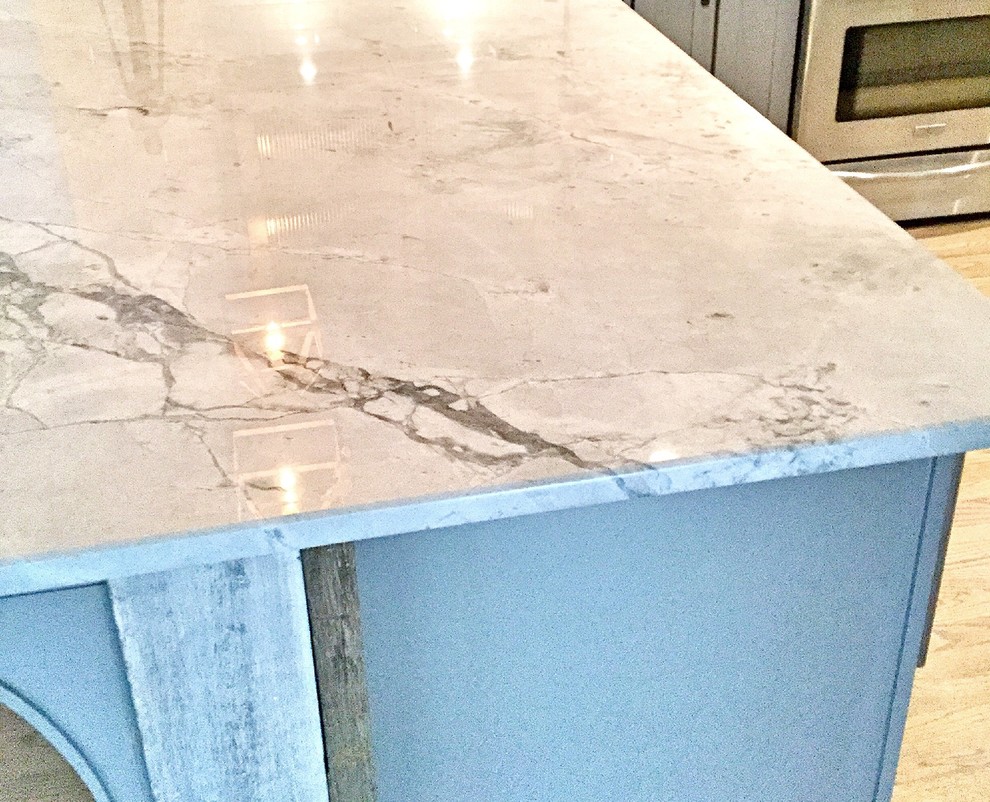 Example of a mid-sized mountain style u-shaped light wood floor open concept kitchen design in Atlanta with a farmhouse sink, shaker cabinets, gray cabinets, quartzite countertops, white backsplash, subway tile backsplash, stainless steel appliances and a peninsula