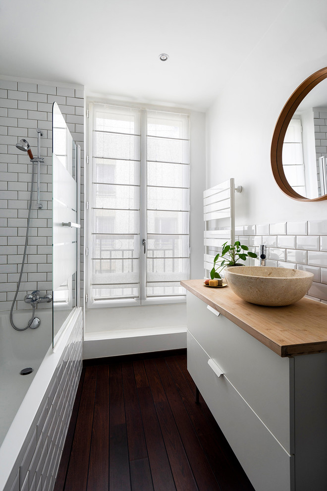 Inspiration for a small contemporary master bathroom in Paris with white cabinets, a shower/bathtub combo, white tile, porcelain tile, white walls, wood benchtops, brown floor, an open shower, brown benchtops, flat-panel cabinets, a corner tub, dark hardwood floors and a vessel sink.