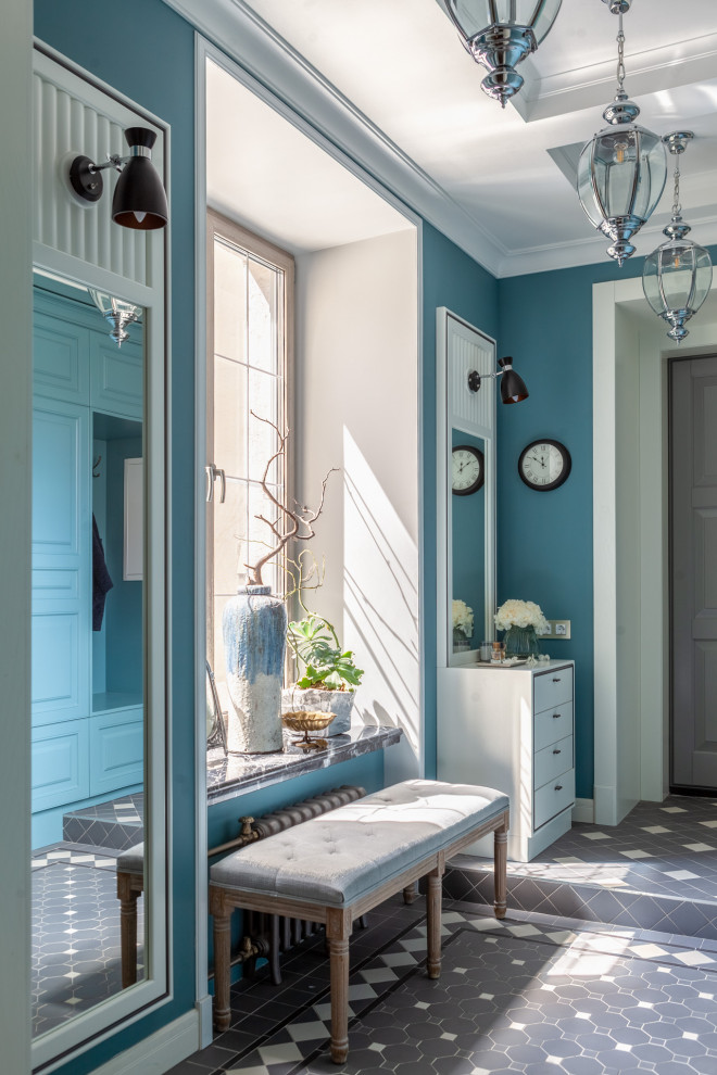 Inredning av en klassisk mellanstor farstu, med blå väggar, klinkergolv i keramik, en enkeldörr, en grå dörr och grått golv