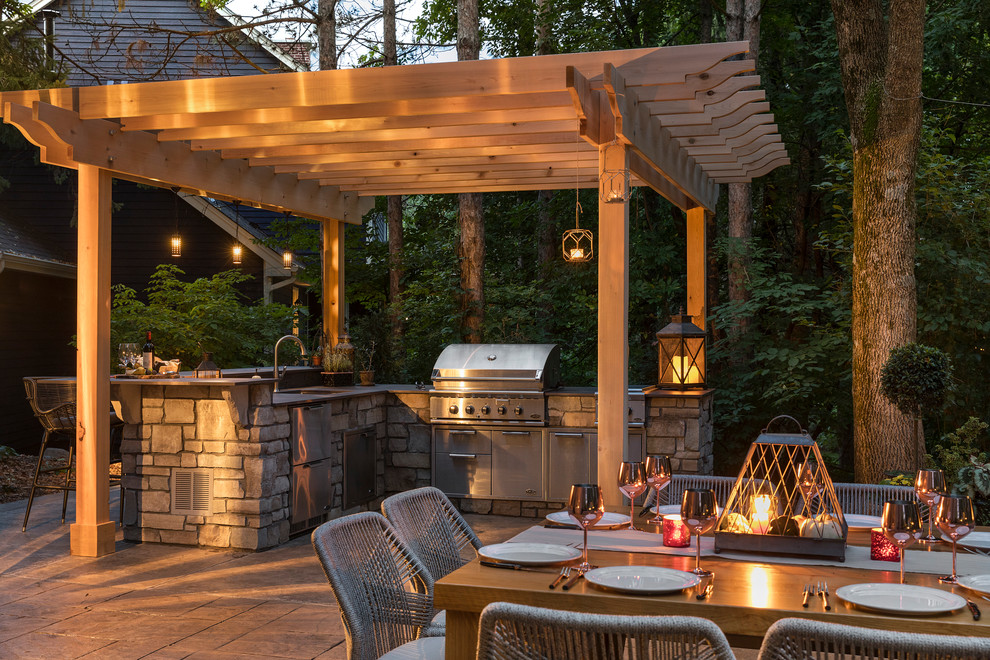 Design ideas for a mid-sized traditional backyard patio in Minneapolis with an outdoor kitchen, natural stone pavers and a pergola.