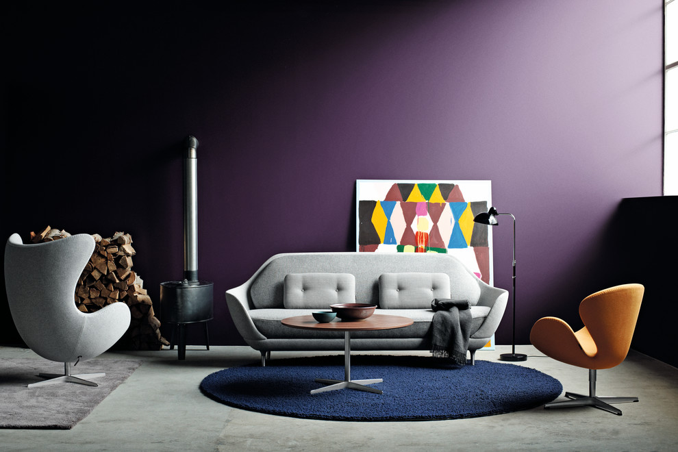 Aménagement d'un petit salon scandinave ouvert avec une salle de réception, un mur violet, sol en béton ciré, un poêle à bois et un manteau de cheminée en métal.