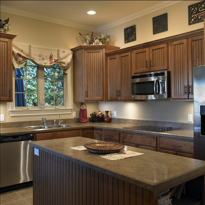 This is an example of a mid-sized traditional l-shaped eat-in kitchen in Indianapolis with a drop-in sink, shaker cabinets, dark wood cabinets, quartz benchtops, stainless steel appliances, ceramic floors and with island.