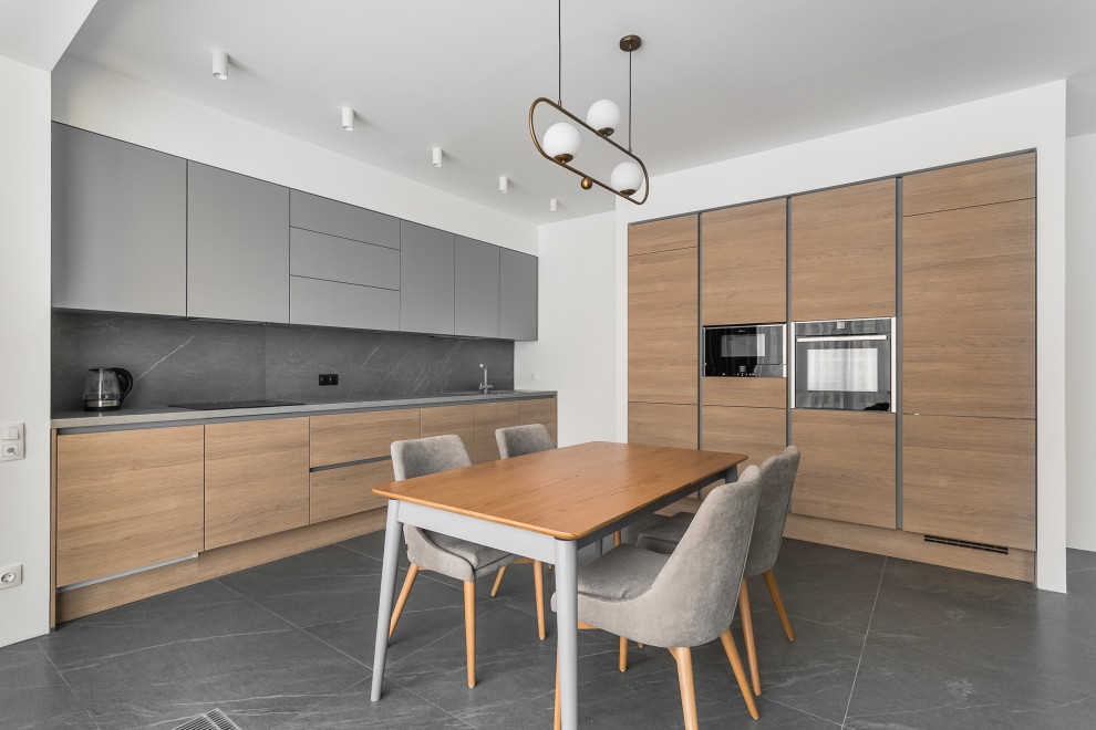 Inspiration for a mid-sized contemporary l-shaped eat-in kitchen in Moscow with an undermount sink, flat-panel cabinets, medium wood cabinets, grey splashback, porcelain splashback, panelled appliances, porcelain floors, no island, grey floor and grey benchtop.