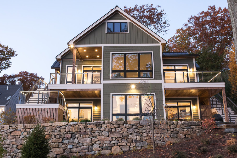 Exemple d'une grande façade de maison verte craftsman en bardeaux à un étage avec un revêtement en vinyle, un toit à deux pans, un toit en métal et un toit marron.