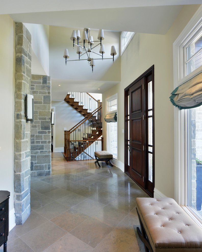 Mid-sized transitional limestone floor foyer photo in Toronto with beige walls and a dark wood front door