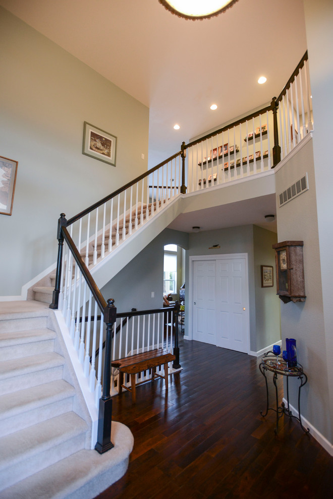 Design ideas for a large traditional carpeted u-shaped staircase in Denver with carpet risers and wood railing.