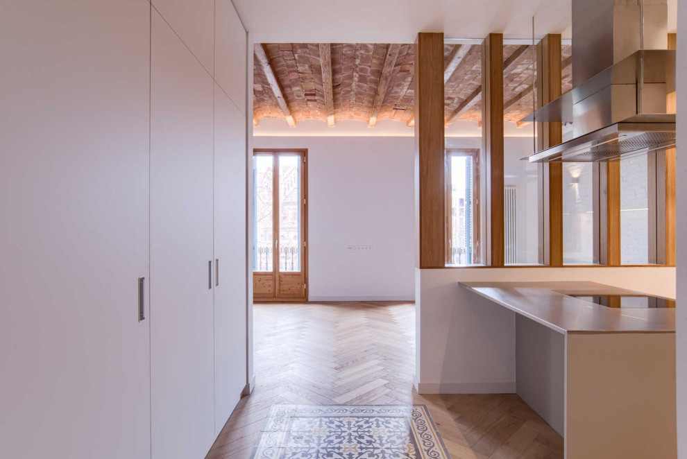 Inspiration for a medium sized eclectic l-shaped open plan kitchen in Barcelona with a submerged sink, recessed-panel cabinets, grey cabinets, stainless steel worktops, grey splashback, metal splashback, integrated appliances, medium hardwood flooring, an island, beige floors, grey worktops and exposed beams.