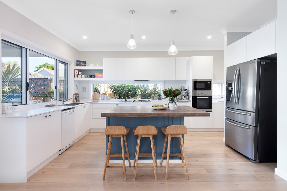 Inspiration for a contemporary u-shaped kitchen in Sydney with a double-bowl sink, flat-panel cabinets, white cabinets, wood benchtops, grey splashback, stainless steel appliances, medium hardwood floors, with island, beige floor and white benchtop.