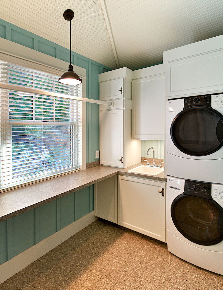 Beach style laundry room in Other with a stacked washer and dryer.