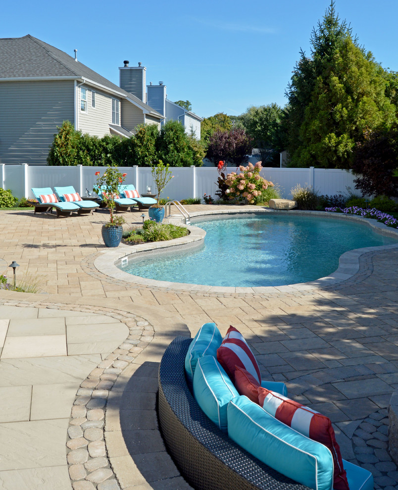 This is an example of a large contemporary backyard custom-shaped pool in New York with concrete pavers.
