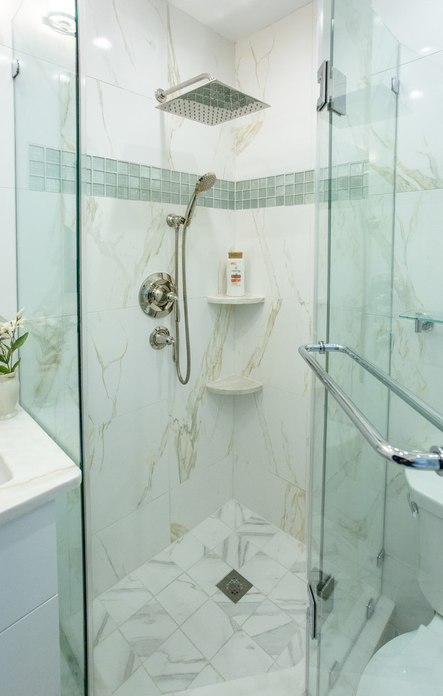 Photo of a small contemporary master bathroom in DC Metro with an undermount sink, flat-panel cabinets, white cabinets, marble benchtops, a corner shower, white tile, porcelain tile, white walls and porcelain floors.