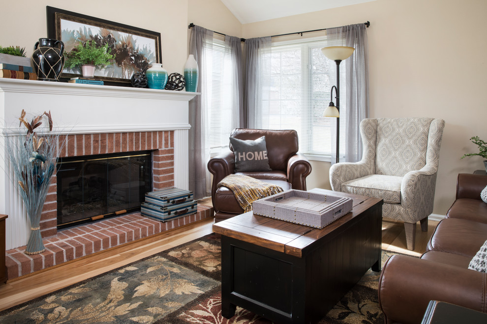 This is an example of a mid-sized traditional living room in Milwaukee with beige walls, a standard fireplace, a brick fireplace surround, no tv, medium hardwood floors and brown floor.