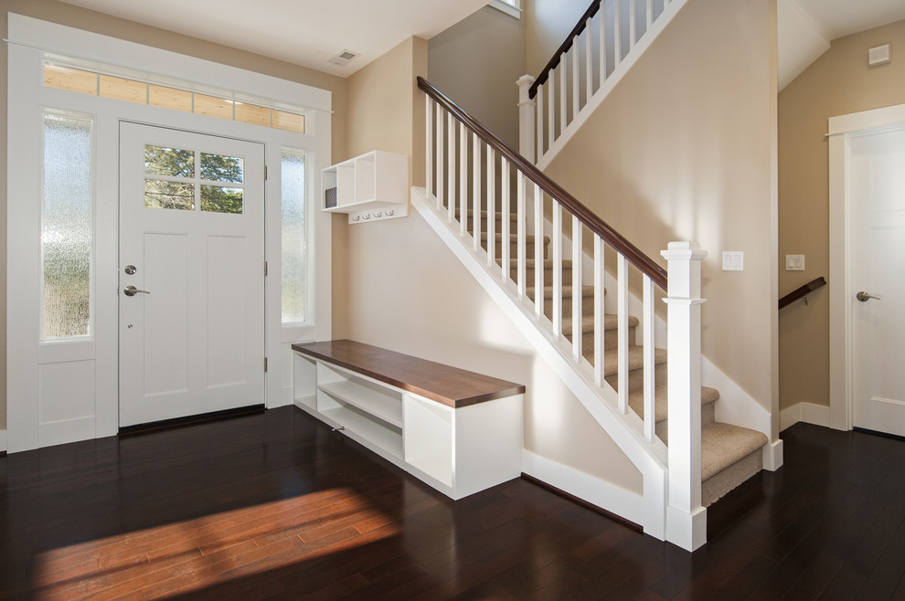 Example of a mid-sized transitional dark wood floor foyer design in Seattle with beige walls and a white front door