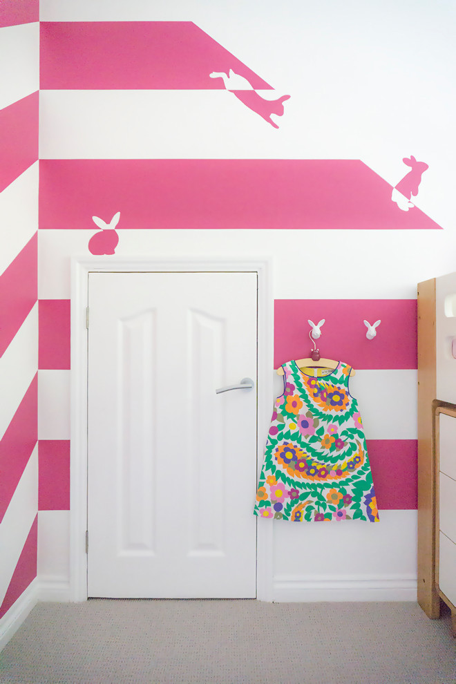 Photo of a small contemporary kids' bedroom for kids 4-10 years old and girls in Hertfordshire with pink walls, carpet and grey floor.