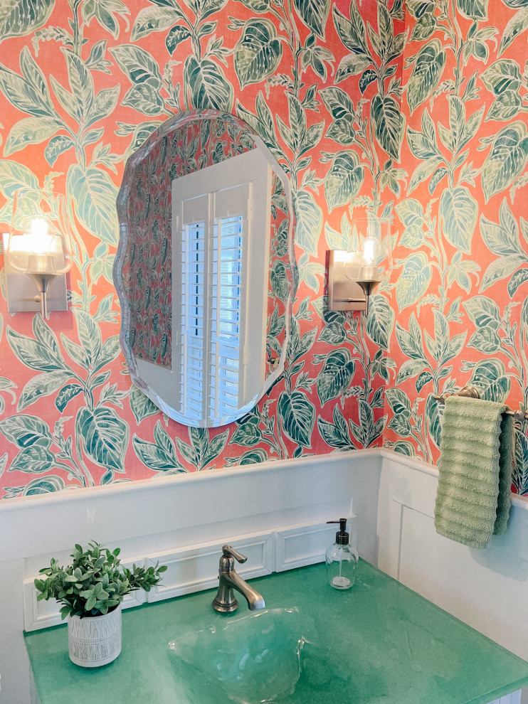 This is an example of a small traditional cloakroom in Portland Maine with louvered cabinets, white cabinets, a one-piece toilet, pink walls, ceramic flooring, an integrated sink, glass worktops, grey floors, green worktops, a freestanding vanity unit and wallpapered walls.