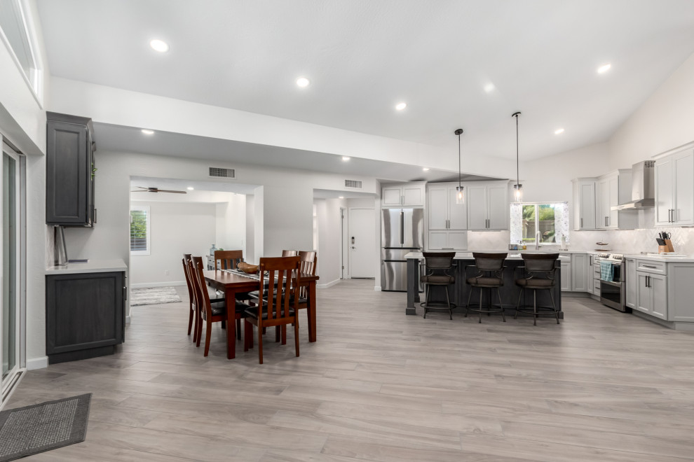 Eat-in kitchen - mid-sized transitional porcelain tile and gray floor eat-in kitchen idea in Phoenix with an undermount sink, shaker cabinets, gray cabinets, quartz countertops, white backsplash, subway tile backsplash, stainless steel appliances, an island and white countertops