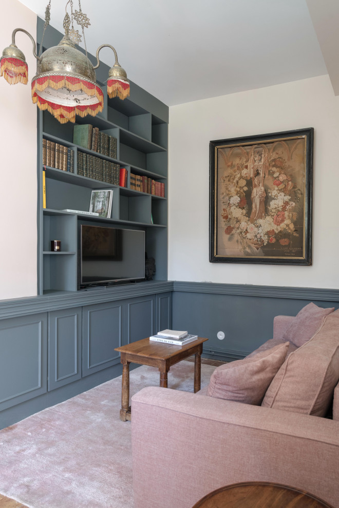 Design ideas for a mid-sized transitional enclosed living room in Lyon with a library, grey walls, terra-cotta floors, no fireplace and a freestanding tv.