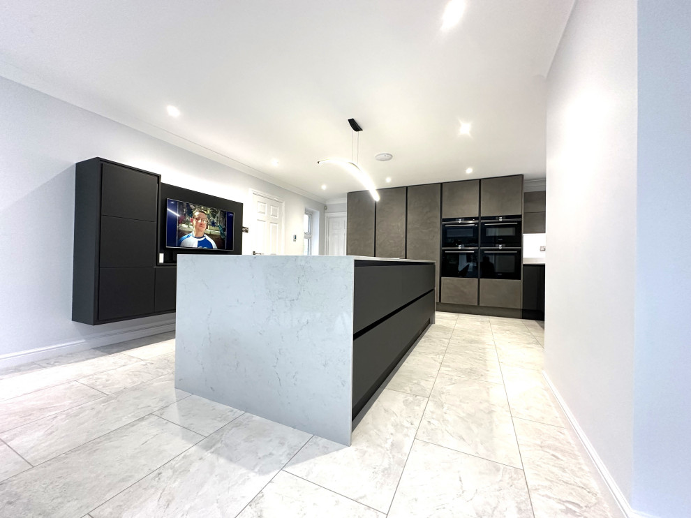 Large contemporary kitchen in Other with a single-bowl sink, flat-panel cabinets, black appliances, vinyl floors and with island.