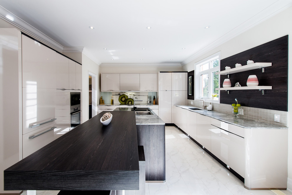 Inspiration for a mid-sized contemporary u-shaped kitchen remodel in Toronto with flat-panel cabinets, quartz countertops, paneled appliances and an island