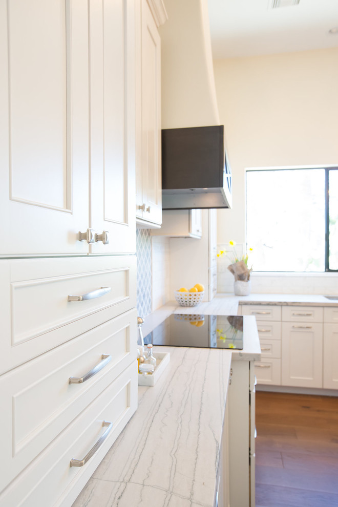 Inspiration for a large transitional l-shaped medium tone wood floor open concept kitchen remodel in Phoenix with an undermount sink, shaker cabinets, white cabinets, quartzite countertops, marble backsplash, stainless steel appliances and an island