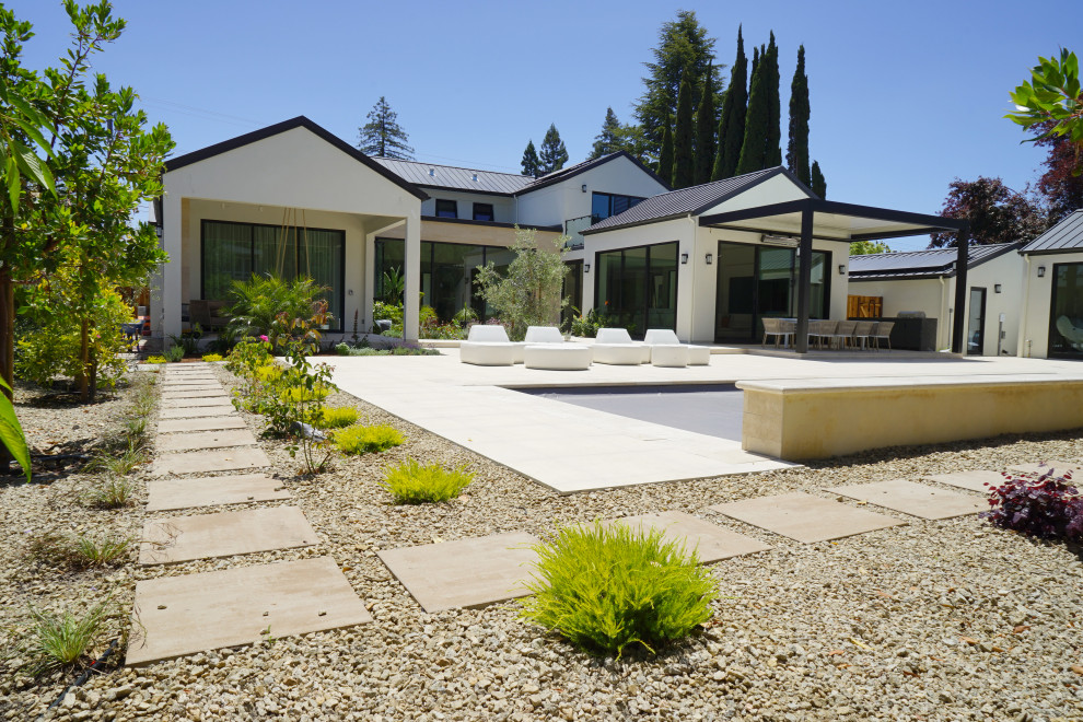 Large trendy backyard gravel and rectangular lap pool landscaping photo