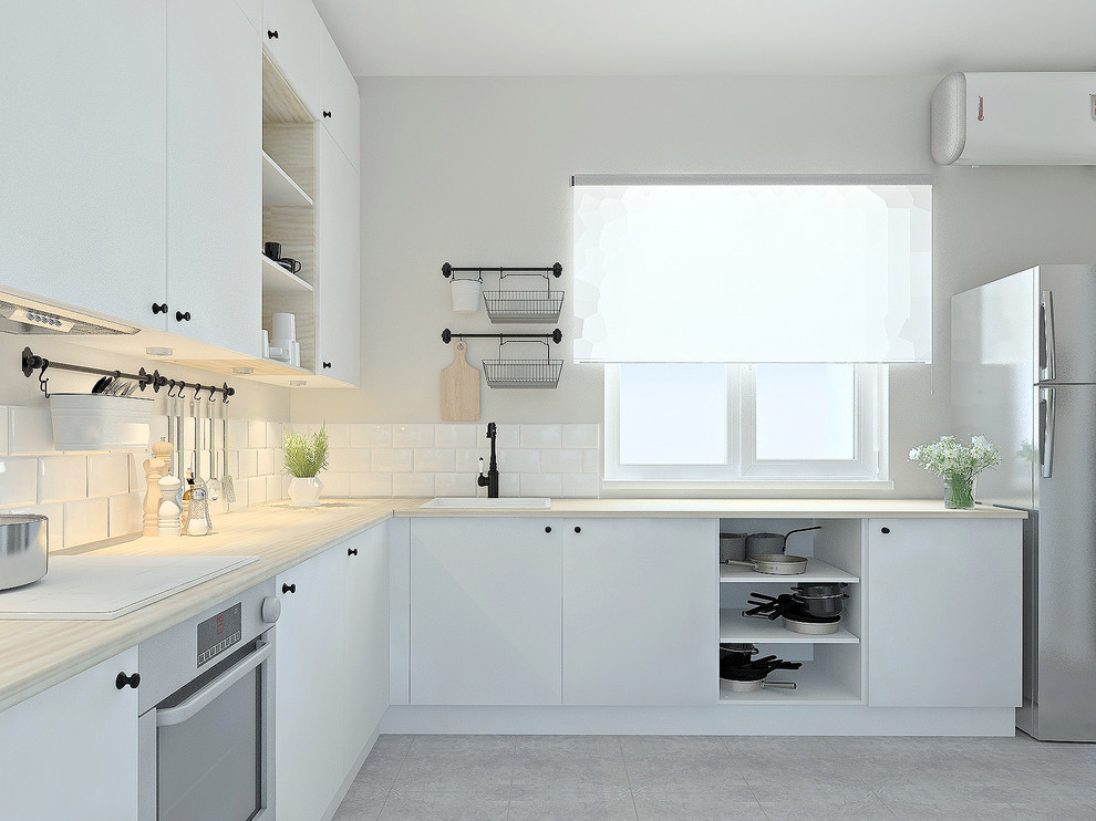 Inspiration for a mid-sized scandinavian l-shaped eat-in kitchen in Other with a single-bowl sink, flat-panel cabinets, white cabinets, wood benchtops, white splashback, stainless steel appliances, porcelain floors, no island, grey floor, beige benchtop and subway tile splashback.