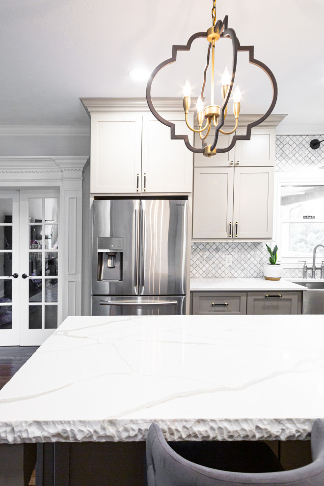 Example of a mid-sized transitional l-shaped medium tone wood floor and brown floor eat-in kitchen design in Other with a farmhouse sink, shaker cabinets, gray cabinets, quartz countertops, gray backsplash, marble backsplash, stainless steel appliances, an island and gray countertops
