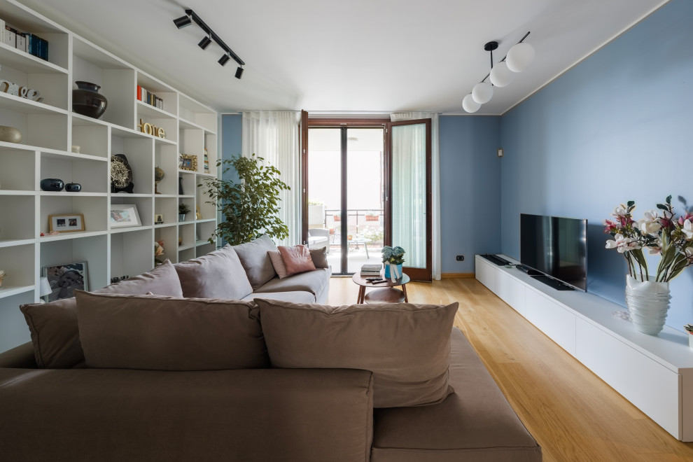 Foto di un soggiorno minimal di medie dimensioni e aperto con libreria, pareti bianche, parquet chiaro, parete attrezzata e pavimento beige