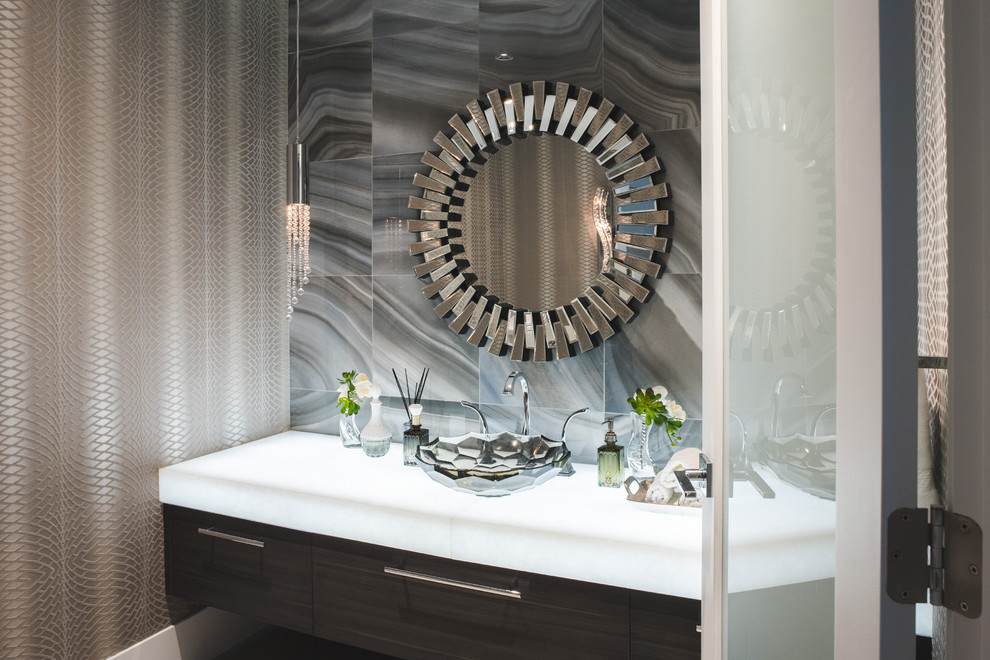 This is an example of a mid-sized contemporary powder room in Vancouver with flat-panel cabinets, dark wood cabinets, gray tile, marble, beige walls, dark hardwood floors, a vessel sink, soapstone benchtops and brown floor.