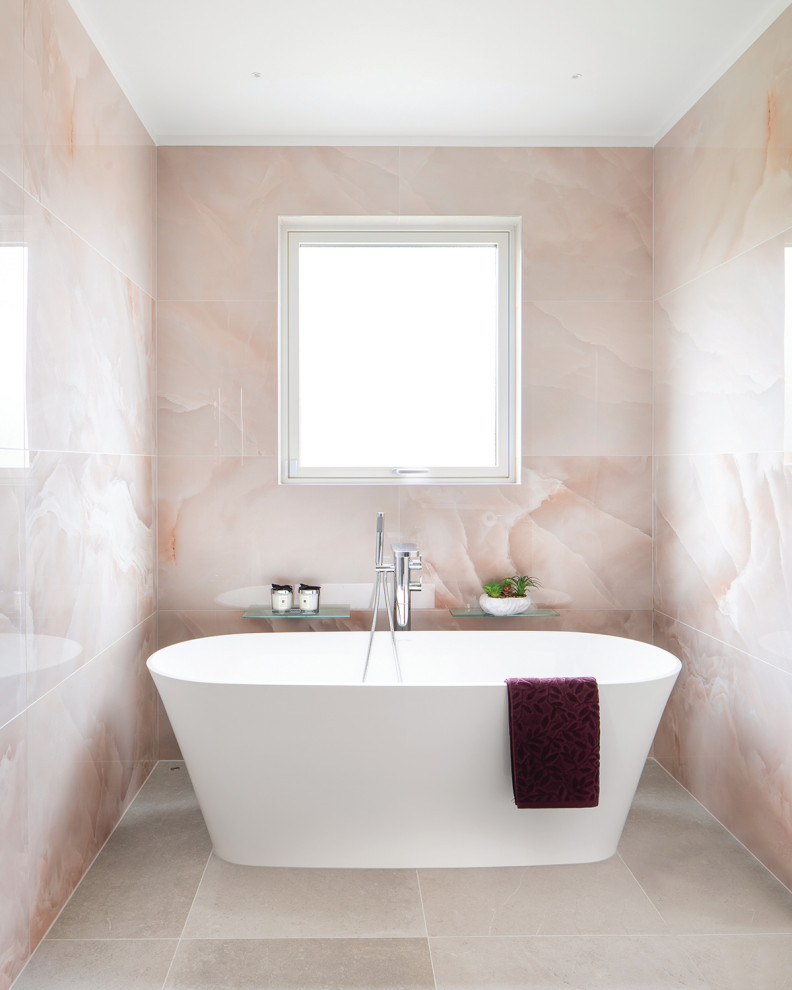 На фото: большая главная ванная комната в стиле модернизм с фасадами в стиле шейкер, красными фасадами, отдельно стоящей ванной, душем без бортиков, инсталляцией, розовой плиткой, керамогранитной плиткой, розовыми стенами, полом из известняка, врезной раковиной, столешницей из кварцита, серым полом, открытым душем, белой столешницей, тумбой под одну раковину и подвесной тумбой с