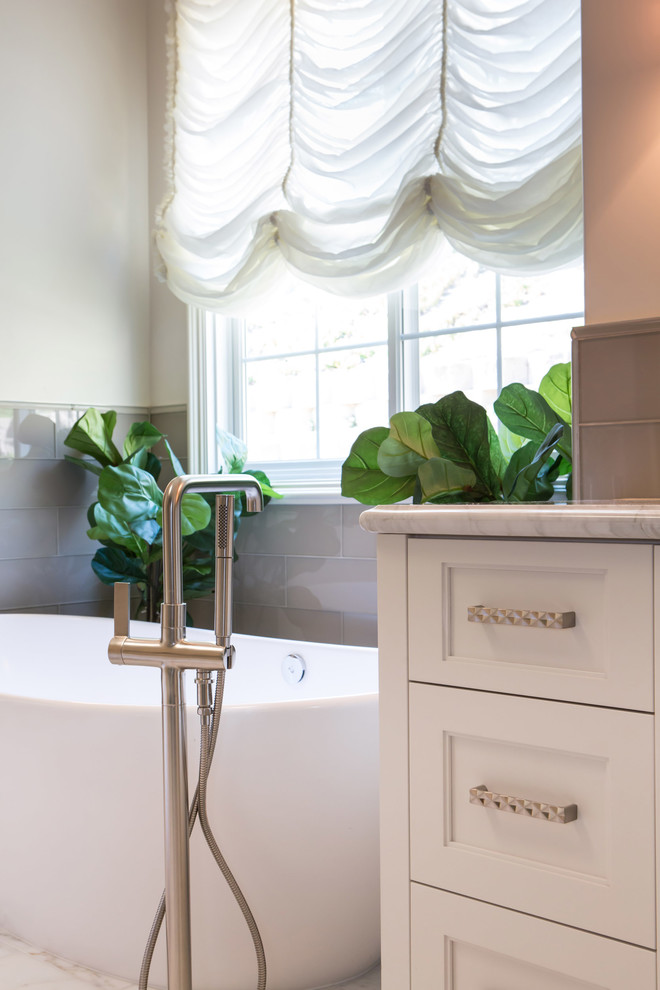 Design ideas for a large traditional master bathroom in San Diego with shaker cabinets, white cabinets, a freestanding tub, a corner shower, a one-piece toilet, white tile, glass tile, white walls, marble floors, an undermount sink and marble benchtops.