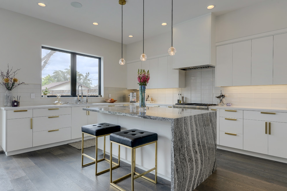 This is an example of a mid-sized contemporary l-shaped kitchen in San Francisco with flat-panel cabinets, white cabinets, white splashback, medium hardwood floors, with island, grey floor and grey benchtop.