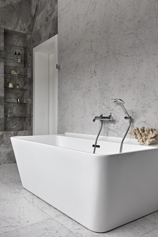 Exempel på ett mellanstort modernt vit vitt en-suite badrum, med släta luckor, skåp i mellenmörkt trä, ett fristående badkar, en dusch i en alkov, en vägghängd toalettstol, grå kakel, porslinskakel, grå väggar, klinkergolv i porslin, ett undermonterad handfat, bänkskiva i akrylsten, grått golv och med dusch som är öppen