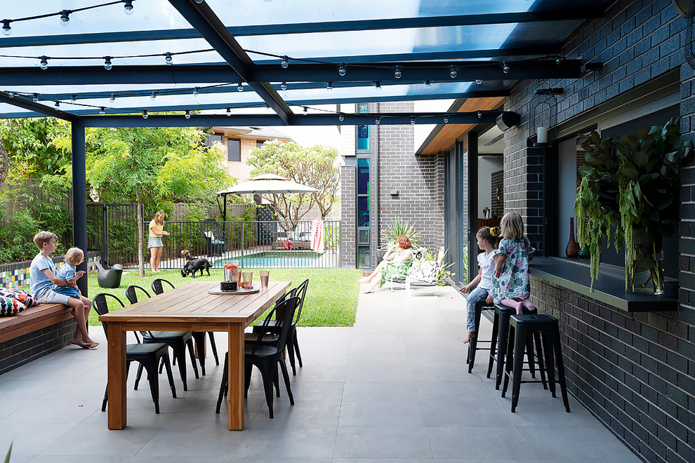 This is an example of a mid-sized midcentury backyard patio in Perth with a pergola.