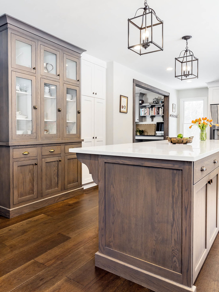 Example of a transitional l-shaped eat-in kitchen design in Providence with a farmhouse sink, shaker cabinets, white cabinets, quartzite countertops, white backsplash, subway tile backsplash, stainless steel appliances and an island
