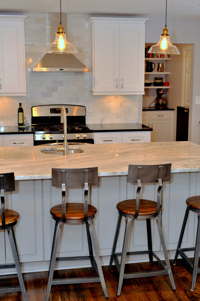 Example of a mid-sized transitional l-shaped medium tone wood floor open concept kitchen design in Atlanta with a double-bowl sink, white cabinets, quartzite countertops, white backsplash, stainless steel appliances and an island