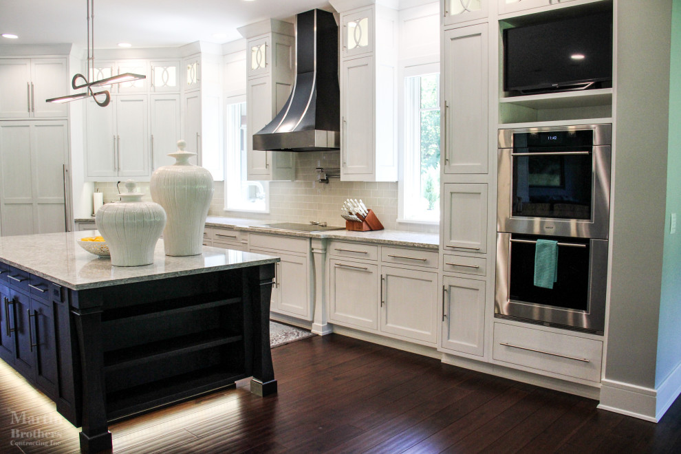 Example of a huge transitional l-shaped dark wood floor kitchen pantry design with an undermount sink, shaker cabinets, white cabinets, quartzite countertops, gray backsplash, ceramic backsplash, stainless steel appliances and two islands