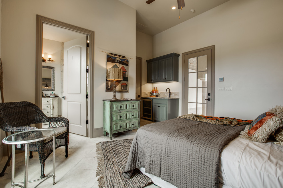 Design ideas for a mid-sized mediterranean guest bedroom in Dallas with beige walls, porcelain floors, a standard fireplace and a stone fireplace surround.