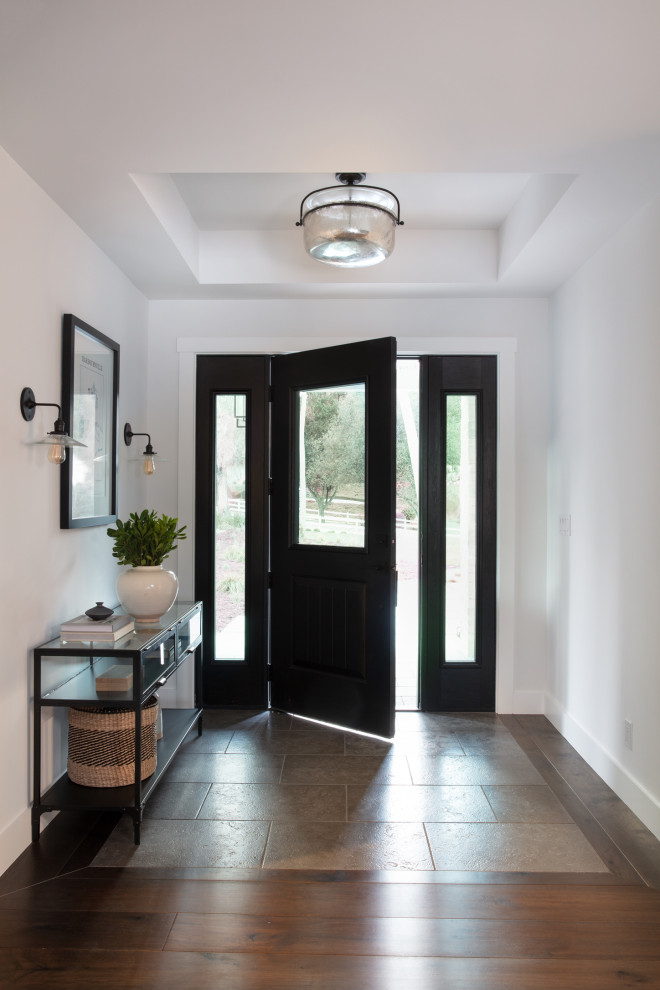 Пример оригинального дизайна: входная дверь среднего размера в стиле кантри с белыми стенами, темным паркетным полом, одностворчатой входной дверью, входной дверью из темного дерева и разноцветным полом